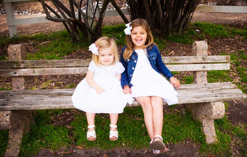 Charlotte and Gwenyth Gray on a bench laughing